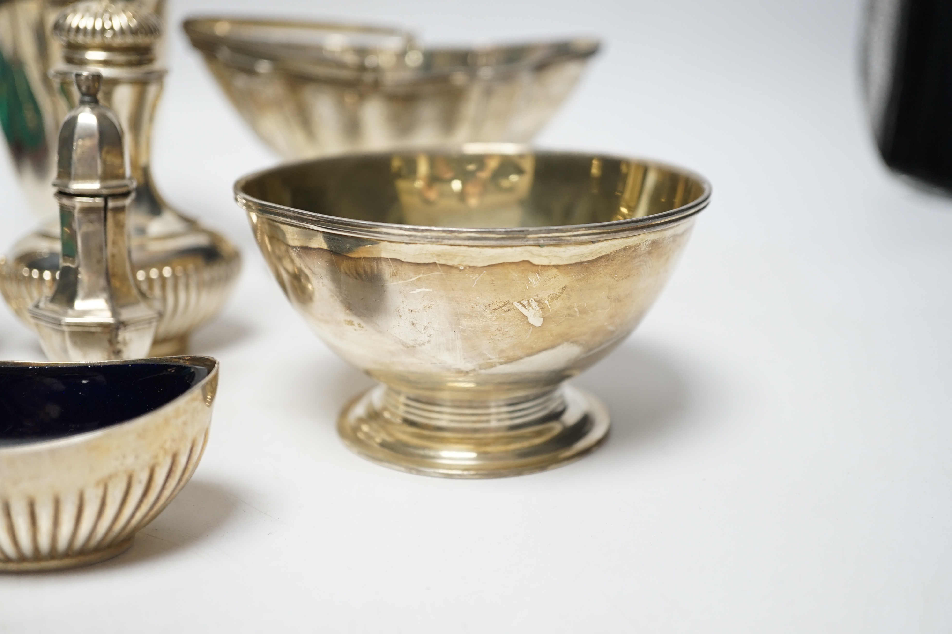 A group of small silver including Edwardian silver oval sugar basket, a modern silver cream jug and sugar bowl, five assorted condiments, a silver sifter spoon and a late Victorian scent bottle, 56mm.